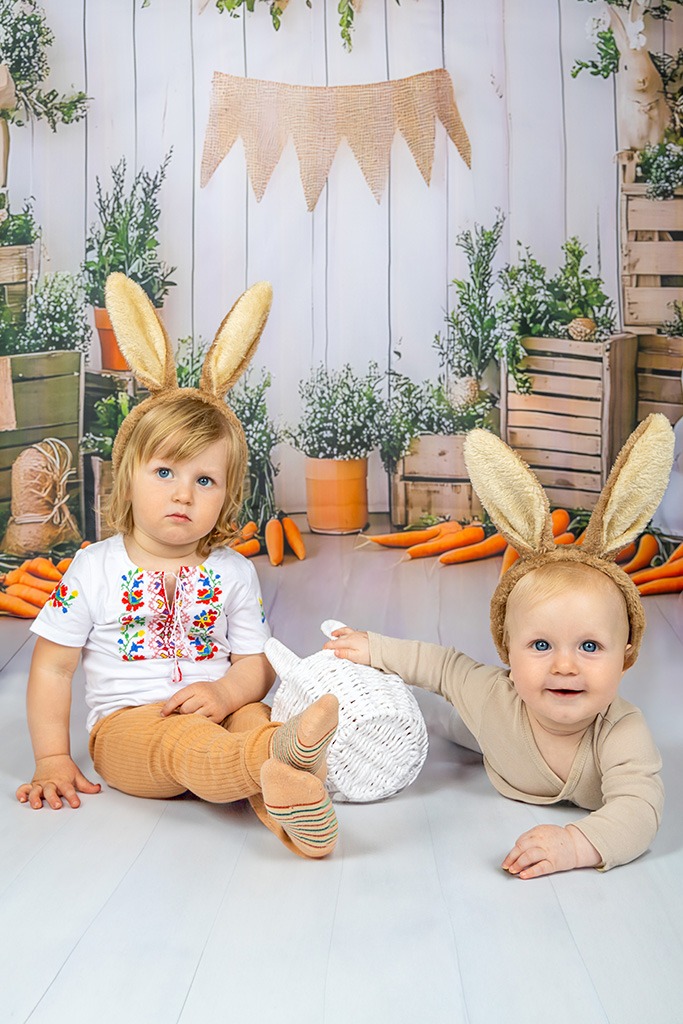 Velikonoční fotografie dvou veselích dětí s králičími uši a dalšimi velikonočními motivy