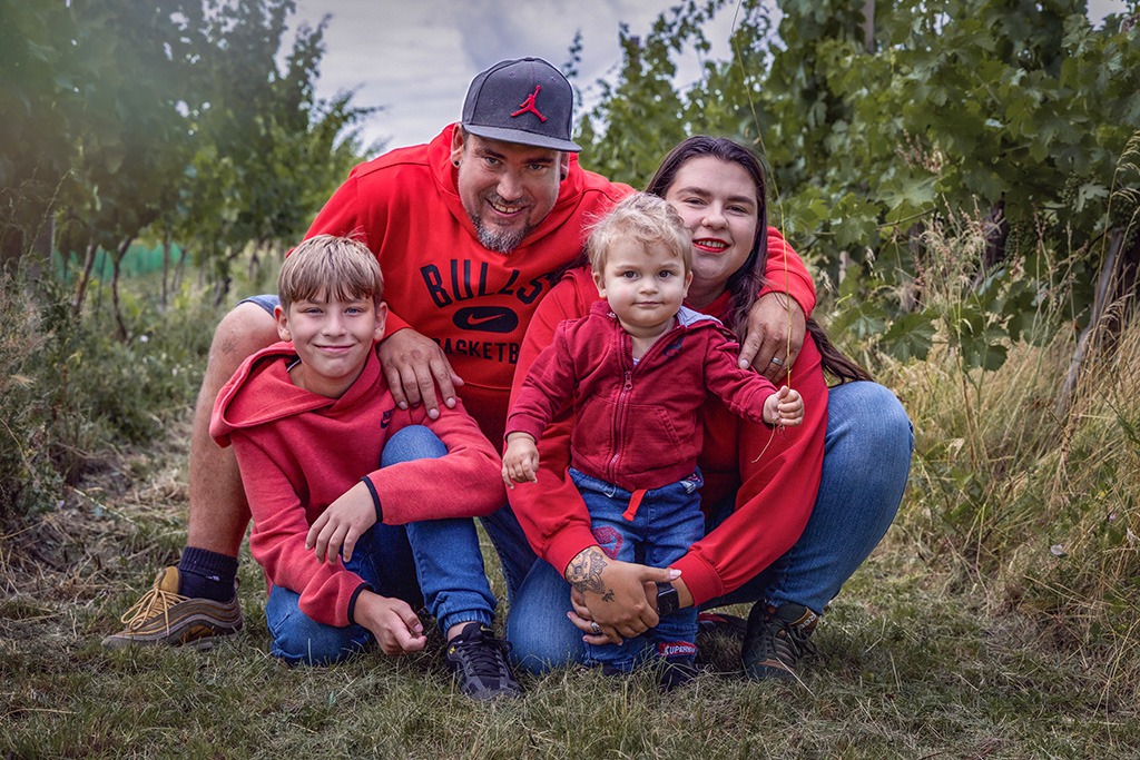 rodinná fotografie, otec, matka a dva synové, sedící na cestě