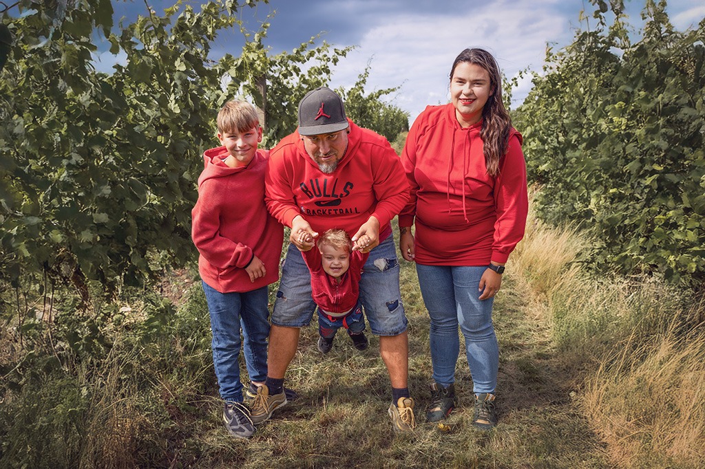 rodinná fotografie, otec, matka a dva synové, stojící na cestě